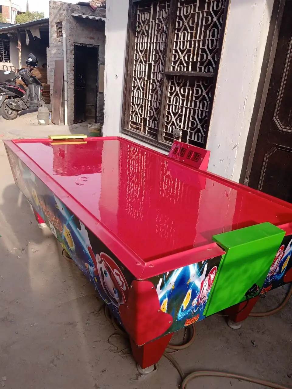 Side view of a red air hockey table ready for event rental in Goa