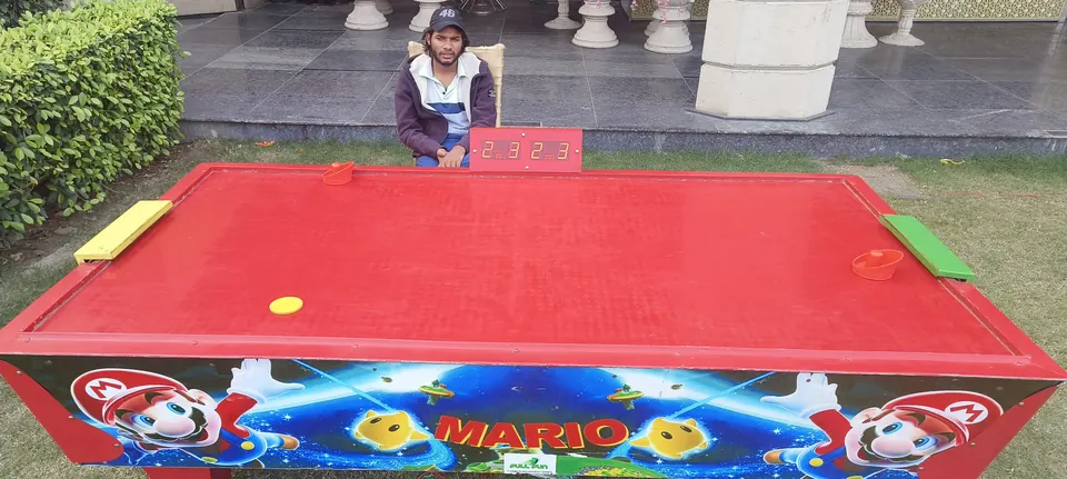 Red air hockey table with digital scoreboard arranged for a Goa party