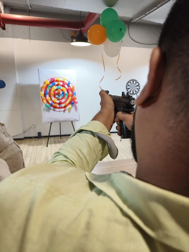 Guest aiming at a balloon shooting target during an event in Goa