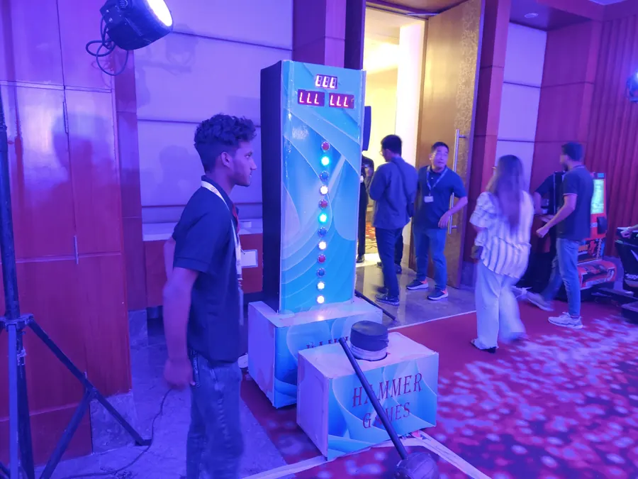 Guests enjoying hammer arcade game during a Goa celebration