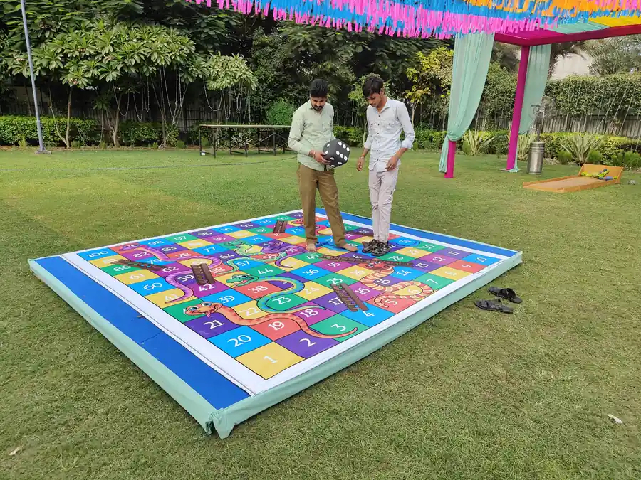 Guests enjoying snake and ladder game during a Goa celebration