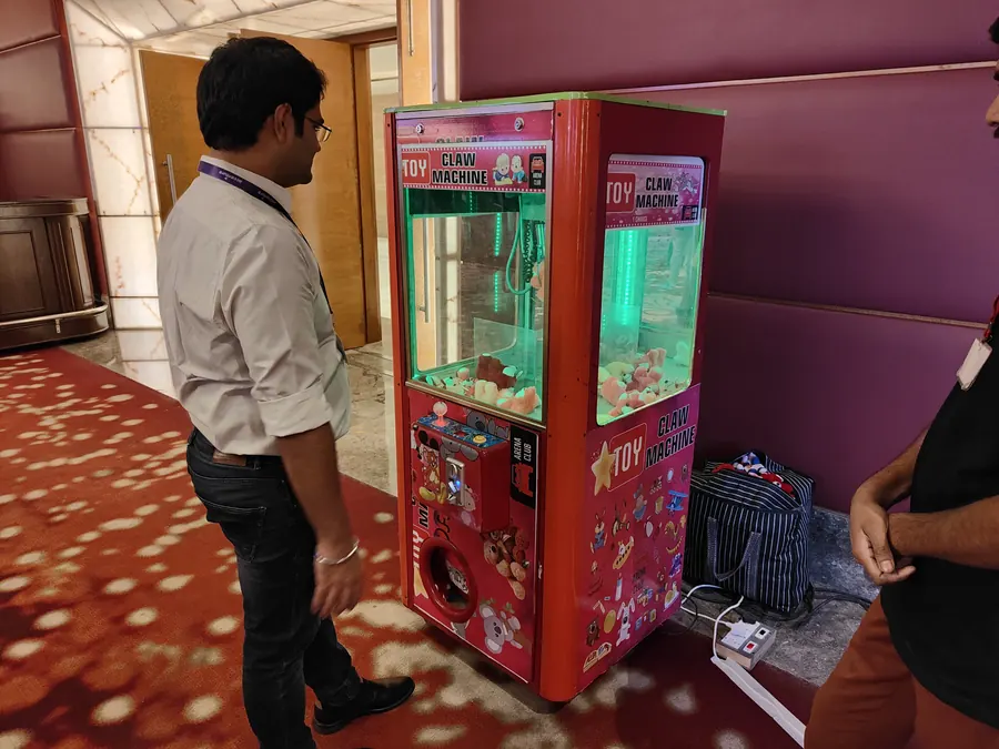 Guests enjoying toy claw machine during a Delhi celebration